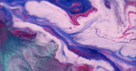 Glitter splash. Color particles. Defocused red purple blue paint water sparkling green white stains flowing on abstract background.の写真素材
