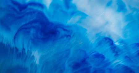 Paint flow. Dye fluid. Blue enamel art blend white acrylic stream. Color mix emulsion texture abstract emulsion defocused background.の写真素材