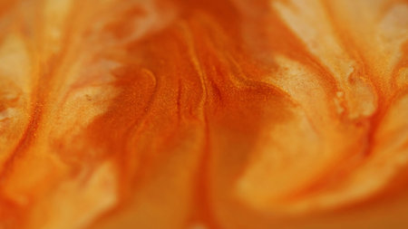 Enamel liquid. Sparkling texture. Defocused yellow orange color paint flowing in water stains spilling on abstract acrylic background.の写真素材