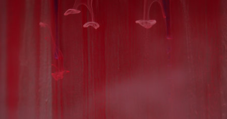 Abstract leaking paint. Blur flow pour. Defocused red colorful shine liquid drops fluid smoke...
