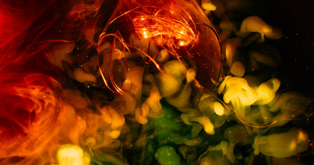 Underwater smoke. Blur light glow. Illuminated garland glass abstract color splash. Red yellow green cloud ink flow on dark sparkling background.の写真素材