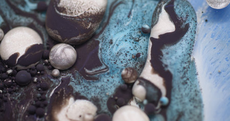 Drop flow. Color liquid. Defocused blue white purple ink water oil bubbles pigment round acrylic floating on abstract art background.の写真素材