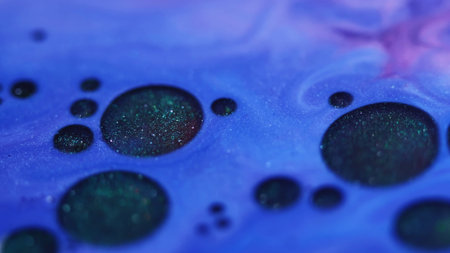 Flowing droplets. Shiny fluid. Defocused blue purple color round paint oil chemical enamel water...