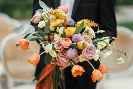The groom hand bouquet of fresh flowers close-upの写真素材