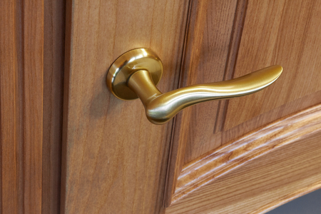 metal door handle in a wooden door, closeup. Door handle in the interior.の写真素材
