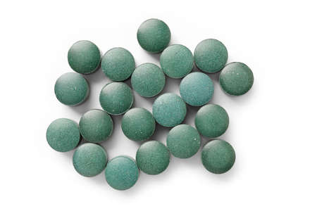 Spirulina tablets on white background isolated. Vitamin and mineral supplements. close-up top-viewの写真素材