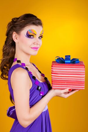 beautiful woman with make up in dress with a gift の写真素材