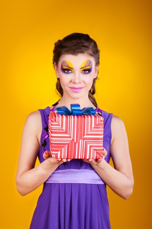 beautiful woman with make up in dress with a gift の写真素材