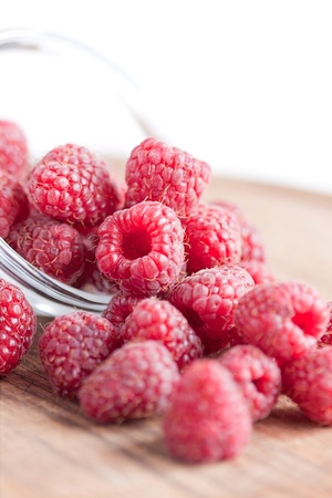 Bowl of raspberries on wooden table close upの写真素材
