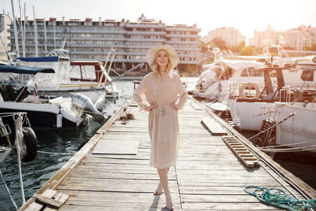 Portrait of a young smiling woman outdoor near sailing boatsの写真素材