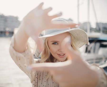 young smiling woman outdoor doing frame with hands like cameraの写真素材