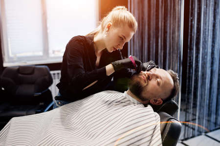 Barber shaving a man in barbershop, close upの写真素材