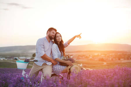 happy couple in laveder field. man and woman in sunset light in blooming lavenderの写真素材