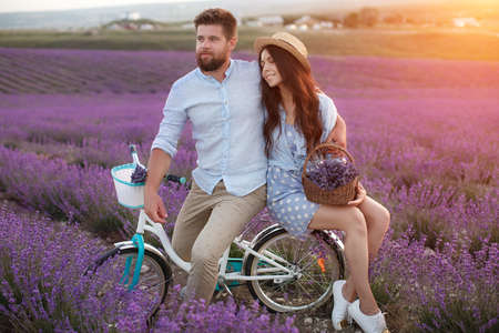 happy couple in laveder field. man and woman in sunset light in blooming lavenderの写真素材