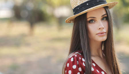 Close up woman portrait outdoor with hatの写真素材