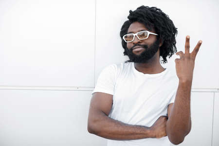 Portrait of a black handsome man outdoor near white background