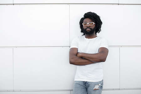 Portrait of a black handsome man outdoor near white background