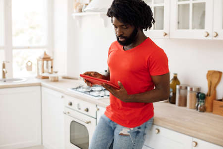 Handsome black african man working at home with tabletの写真素材