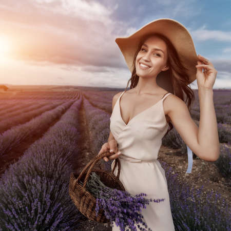 Fashion beautiful model in lavender field in sunsetの写真素材