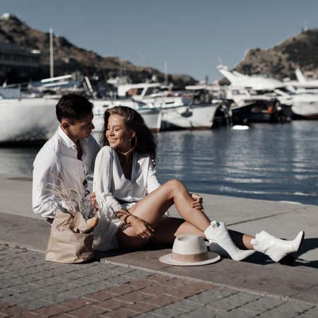 lifestyle engagement photo session young man and woman near yachts, couple in the city