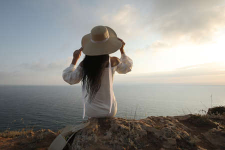 backside Fashion woman in dress and hat near the sea ocean sunsetの写真素材