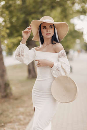 Fashion woman in dress and hat outdoorの写真素材