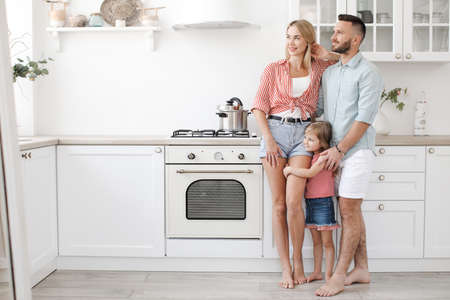 Happy family with daughter in casual wear at home in kitchen