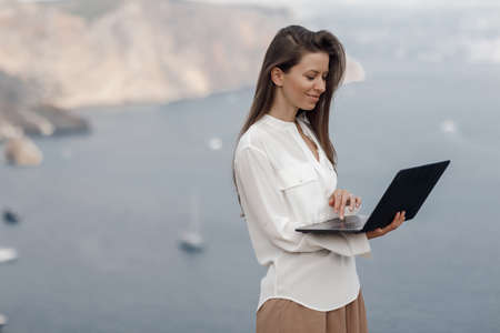 Young happy business woman with laptop outdoorの写真素材