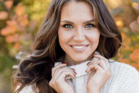 Closeup autumn portrait of a happy young woman outdoorの写真素材