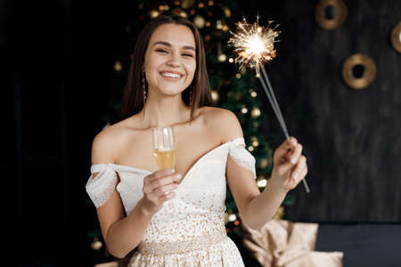 Closeup portrait of a happy pretty woman with champagne, new year and xmasの写真素材
