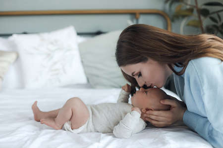 happy mother with little cute newborn at homeの写真素材
