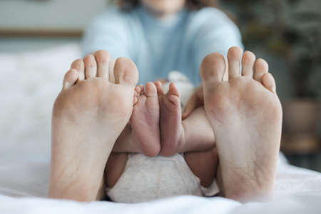 closeup mothers and newborns feet at home