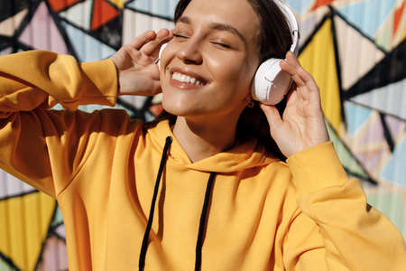 young smiling woman listen to the music in headphones