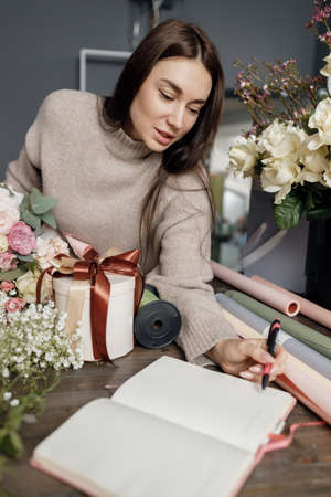 female florist working in studio with flower bouquetの写真素材