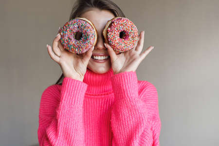 pretty young woman with donut in studioの写真素材