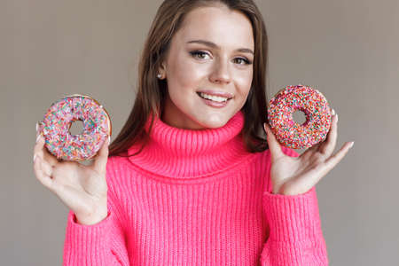 pretty young woman with donut in studioの写真素材