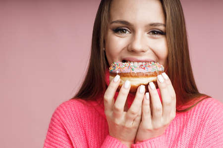 pretty young woman with donut in studioの写真素材