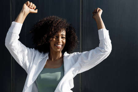 pretty smiling afro woman dancing outdoorsの写真素材