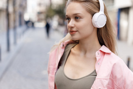 beautiful joyful young woman with headphones outdoorsの写真素材