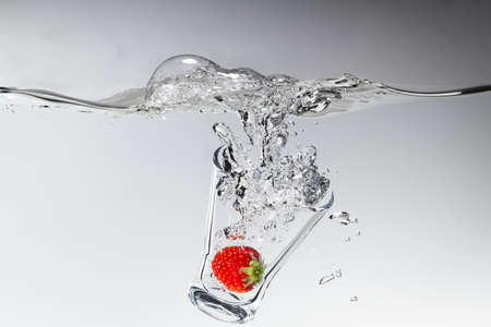 Glass dipping in waterの写真素材