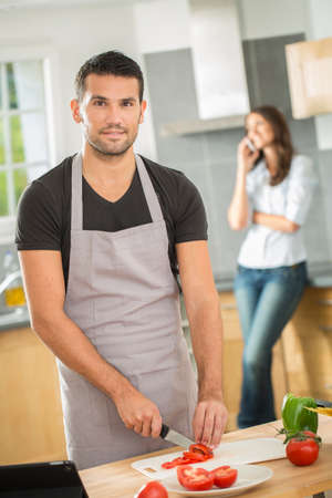 Young couple in kitchen prearing lunchの写真素材
