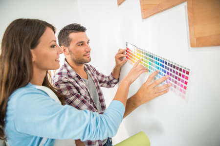 Young couple choosing paint color and pent paperの写真素材
