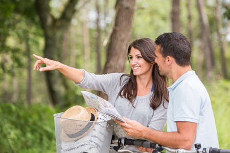 young couple with map and bikeの写真素材