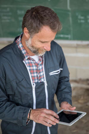 farmer using a digital tablet in a barn