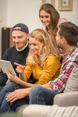 roommates choosing tv program on digital tabletの写真素材