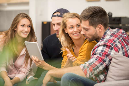 Roommates in apartment using a tabletの写真素材