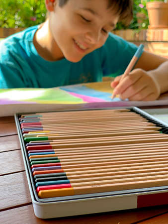 10-year-old boy painting happy with colored pencilsの写真素材