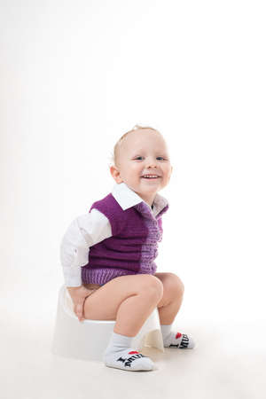 Child with glasses sitting on a pot of white backgroundの写真素材