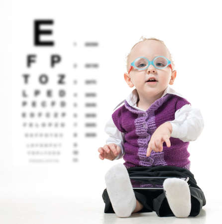 Kid in glasses sitting on the floor on a white backgroundの写真素材