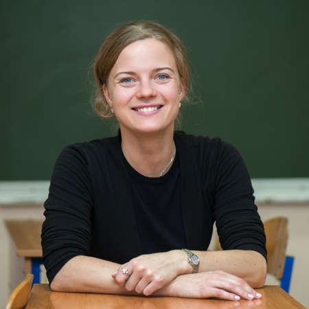 Student girl sitting on chalkboardの写真素材